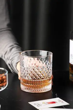 verre à whisky cristal tumbler sur table noire avec main