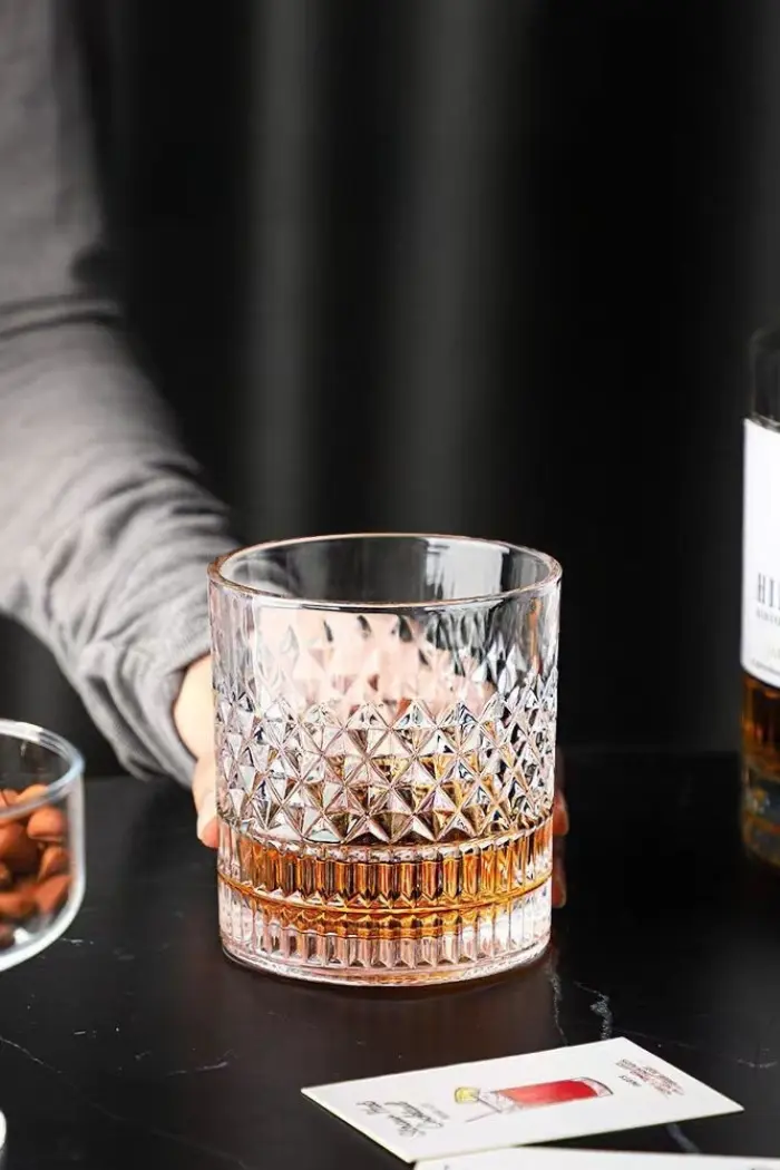 verre à whisky cristal tumbler sur table noire avec main