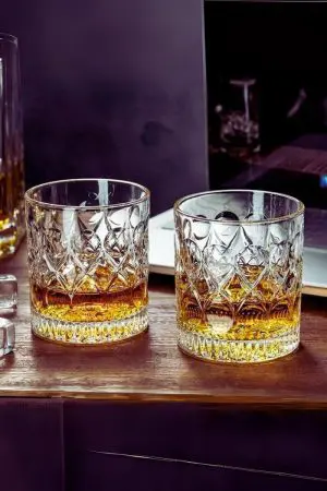 deux verres à whisky cristal 330 ml posés sur table en bois avec fond sombre