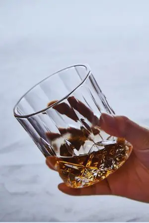 Verres à whisky en cristal sculpté posés sur une table, parfaits pour un apéritif sophistiqué.