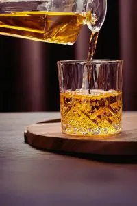 Gros plan sur un verre en cristal sculpté rempli de whisky, révélant ses détails raffinés.