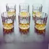 Verres en cristal sculpté parfaitement alignés, illustrant leur finition haut de gamme.