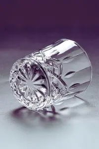 Verre en cristal sculpté incliné, mettant en avant sa forme unique et élégante.