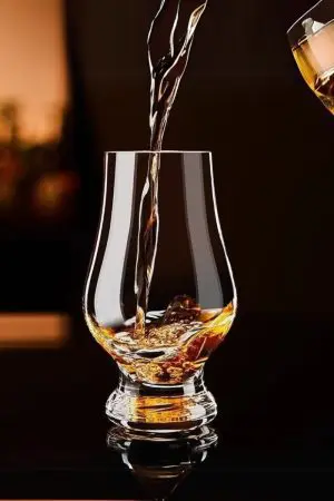 Trois verres Glencairn remplis de whisky sur une table en bois – Expérience de dégustation raffinée
