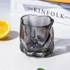 verre à whisky design gris fumé vide posé sur fond blanc avec citron