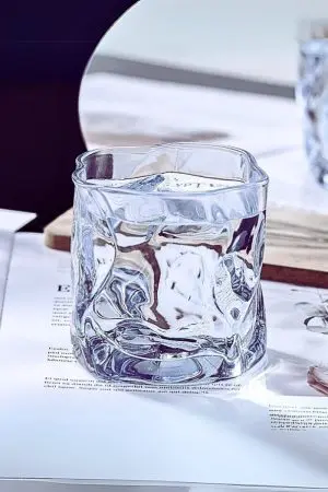 verre à whisky design transparent posé sur un magazine