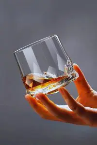 Verre à whisky en cristal design tenu en main - Élégance et prise en main confortable.