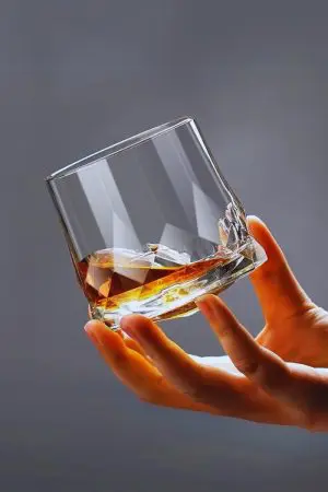 Verre à whisky en cristal design tenu en main - Élégance et prise en main confortable.