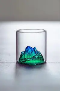 Verre à whisky japonais design montagne verte posé sur table en bois