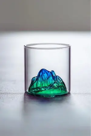 Verre à whisky japonais design montagne verte posé sur table en bois