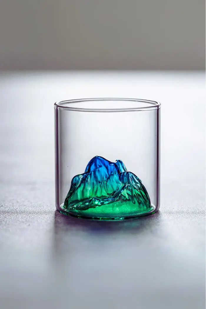Verre à whisky japonais design montagne verte posé sur table en bois