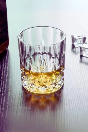Verre en cristal sculpté incliné, révélant son design unique et sophistiqué.