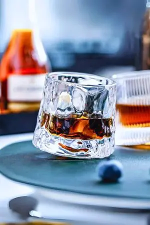 verre à whisky en forme de glaçon posé sur une assiette verte