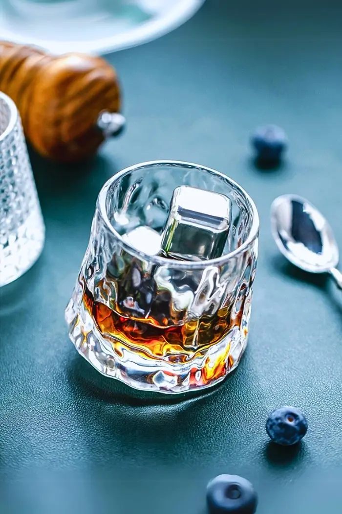 verre à whisky tumbler en forme de glaçon et servi avec glaçons métalliques