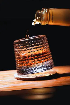 Verre à whisky tumbler en cours de remplissage sur socle rond