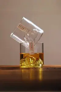 Verre à whisky japonais montagne vide et plein posé sur table avec éclairage naturel