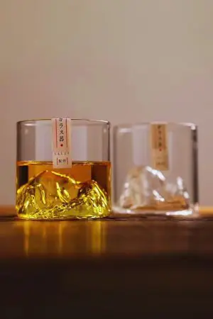 Verre à whisky japonais montagne rempli posé à côté d’une bouteille