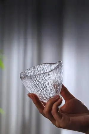 verre à whisky japonais ovale posé sur table en bois foncé avec whisky