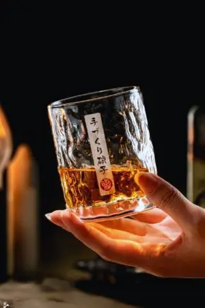 verre à whisky japonais rond tenu en main en pleine dégustation