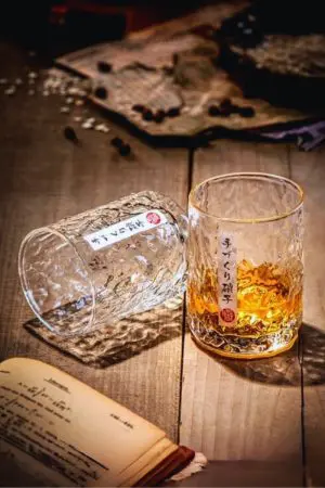 Verres à whisky japonais ronds sur table en bois - un rempli et un allongé vide