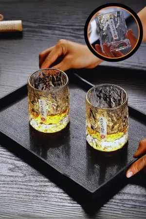 Verre à whisky japonais rond posé sur plateau en bois, rempli de whisky