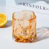 Verre à whisky tumbler ambre vide sur table blanche avec citron.