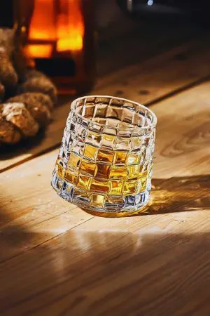verre à whisky tumbler incliné sur une table en bois