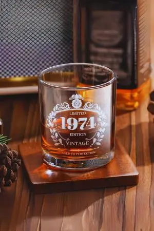 Gros plan sur un verre à whisky vintage 1974, révélant sa gravure et sa texture détaillée.