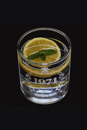 Verre à whisky édition limitée 1974 rempli d’un whisky citron, révélant ses reflets.