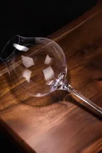 Verre tulipe de dégustation rempli d’un spiritueux ambré, capturant ses reflets dorés.