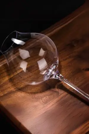 Verre tulipe de dégustation rempli d’un spiritueux ambré, capturant ses reflets dorés.
