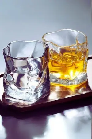 Verre à whisky en cristal teinté tenu en main – Design ergonomique et ondulé.