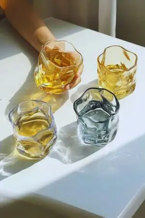 Verres à whisky en cristal teinté – Collection aux reflets colorés et design ondulé.