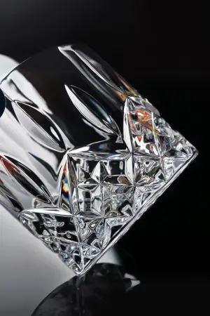 Gros plan sur le cristal sculpté d’un verre à whisky – Détails raffinés et transparence éclatante.