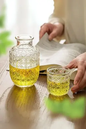 carafe à whisky vintage en verre gravé servant une boisson jaune dans un verre assorti