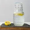 set carafe à whisky vintage avec verre gravé, citron et herbe, sur planche en bois
