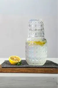 set carafe à whisky vintage avec verre gravé, citron et herbe, sur planche en bois