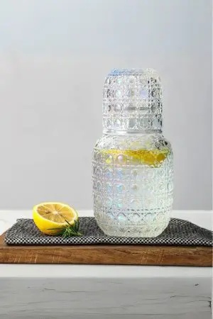 set carafe à whisky vintage avec verre gravé, citron et herbe, sur planche en bois