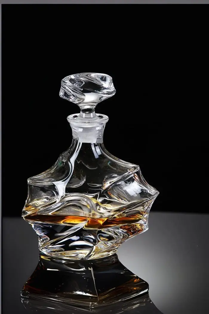 carafe à whisky en cristal design géométrique posée sur une table, boisson ambrée