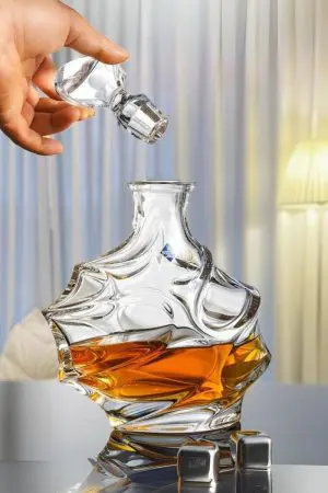 carafe à whisky cristal moderne bouchon sculpté et whisky ambré sur fond noir