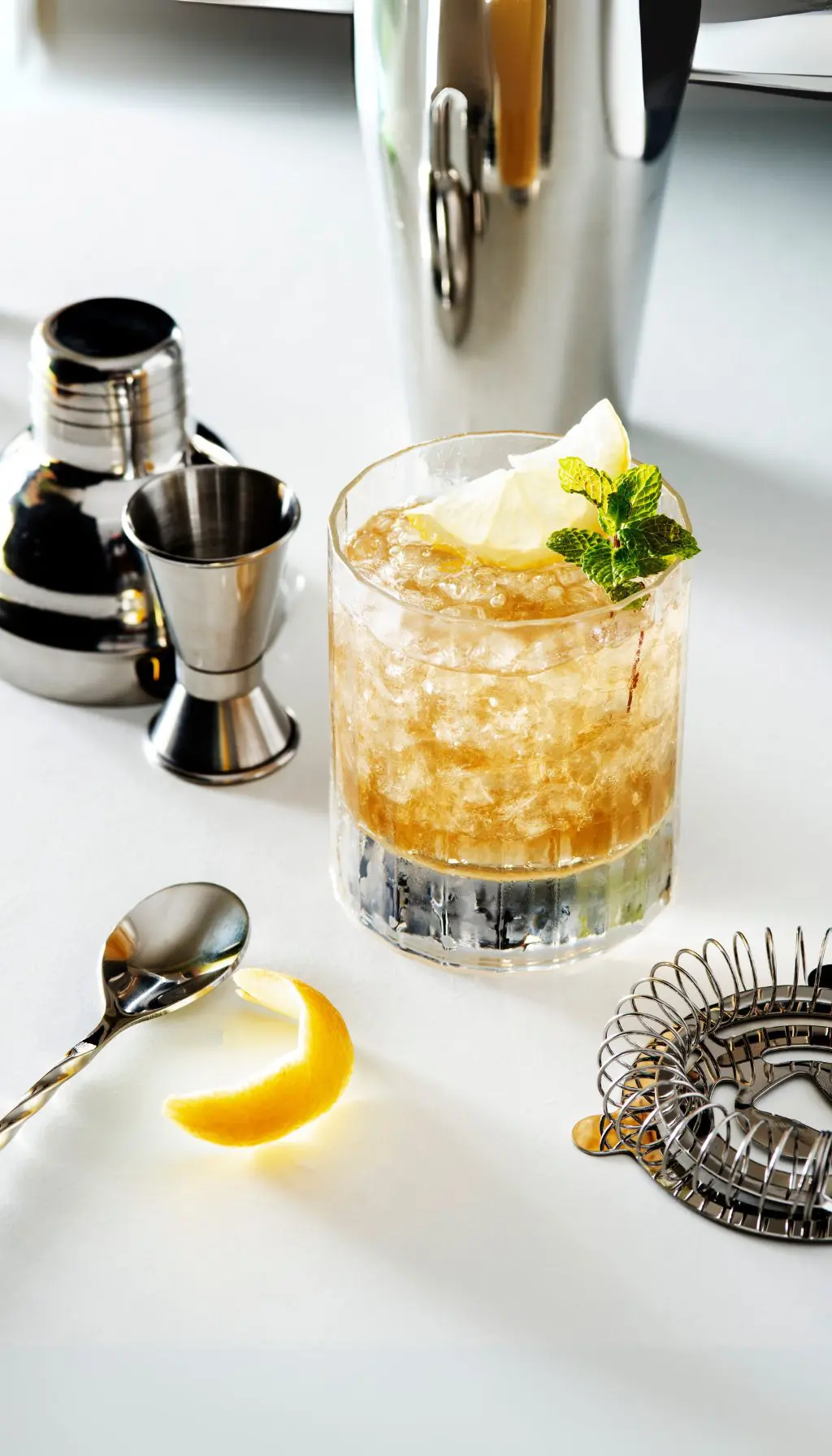 cocktail whisky citron London Collins dans un verre tumbler avec glaçons, zeste de citron et menthe