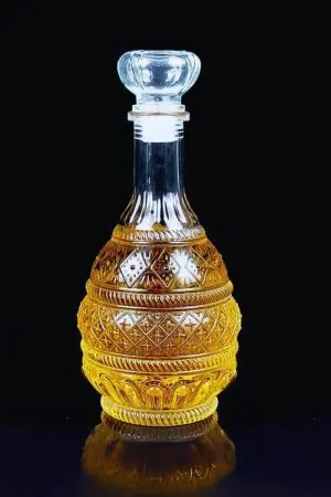 carafe à whisky ronde design 1L en verre avec bouchon posé à côté sur fond noir