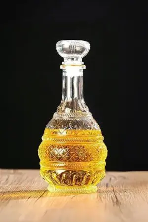 carafe à whisky ronde 1 litre vintage gravée en verre remplie de whisky, fond noir