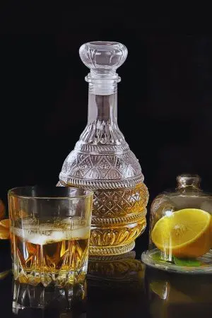 carafe à whisky design ronde vintage 1L en verre gravé remplie de whisky ambré sur table bois