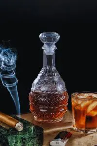 carafe à whisky vintage 1L en verre décoré posée avec verre de whisky et demi-citron
