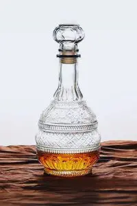 carafe à whisky vintage en verre gravé 1L posée avec verre de whisky et cigare