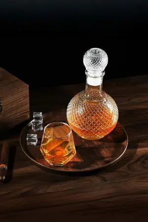 carafe à whisky ronde en verre faceted sphere motif diamant, bouteille sphérique pleine de whisky, bouchon boule en verre assorti, fond noir élégant