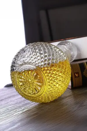 carafe à whisky ronde faceted sphere en verre 1 litre, bouchon boule, accompagnée d’un verre à whisky vintage assorti, boisson dorée, fond noir