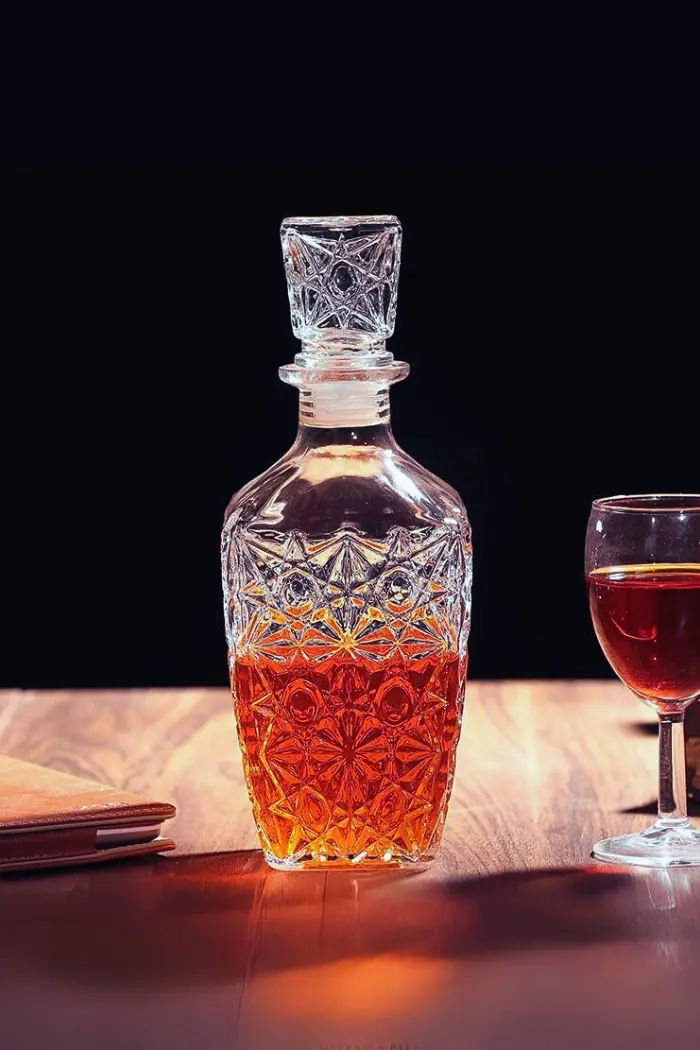 carafe à whisky vintage 800ml en verre design avec bouchon carré et motif étoilé, posée sur une table miroir dorée dans un intérieur lumineux