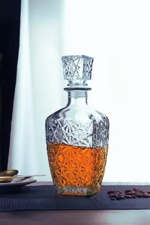 carafe à whisky vintage 800ml en verre avec motifs étoilés, bouchon carré, whisky ambré sur fond noir